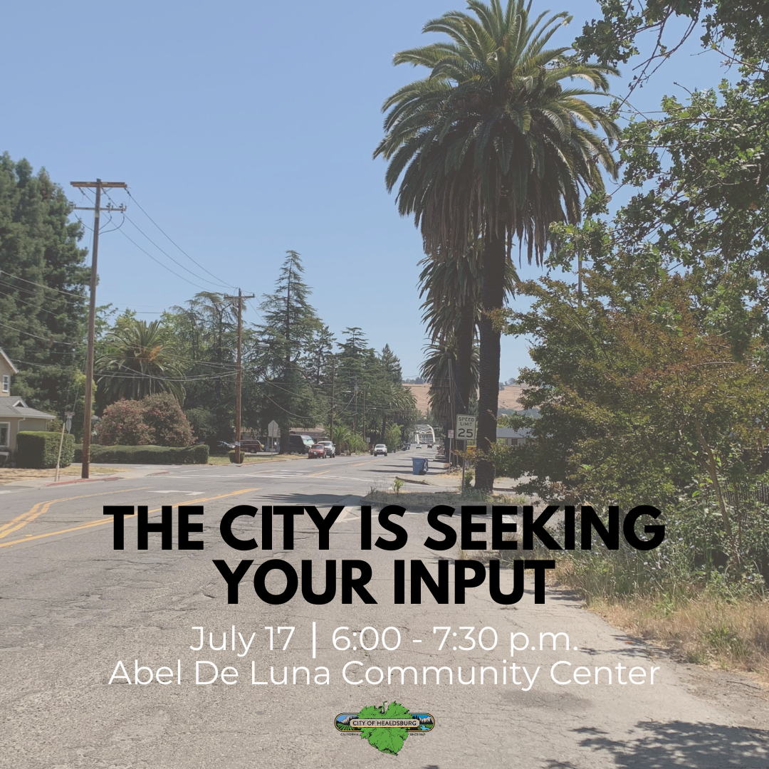 A picture of a street with houses in the background and green trees